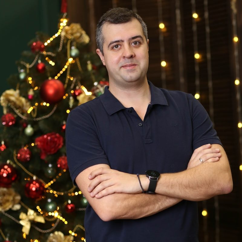 a man standing in front of a christmas tree